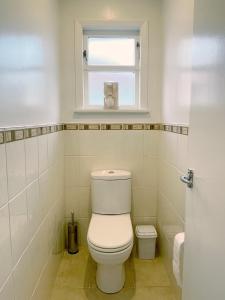 奥克兰Home in central Auckland的白色的浴室设有卫生间和窗户。