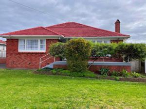 奥克兰Home in central Auckland的红砖房子,有红色屋顶