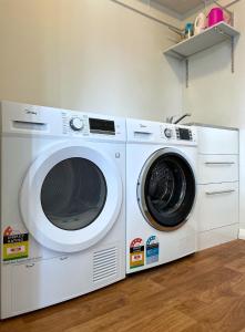 奥克兰Home in central Auckland的两间洗衣机彼此相邻,位于一个房间里