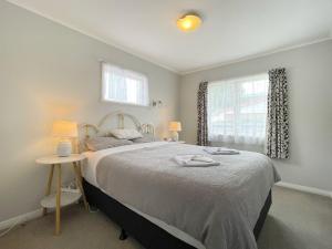 奥克兰Home in central Auckland的一间卧室设有一张大床和一个窗户。