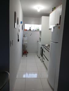 泰谢拉迪弗雷塔斯Flat Sandra的厨房配有白色家电,铺有白色瓷砖地板。