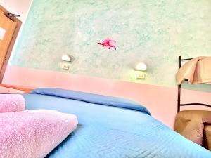 里米尼Hotel Majorca Nuova Gestione Rimini 100 m dalla spiaggia的卧室配有一张床,墙上放风筝