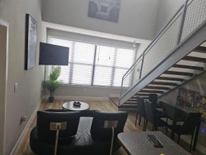 沃思堡Fort Worth 2 bedroom Loft Downtown的客厅设有楼梯和桌椅