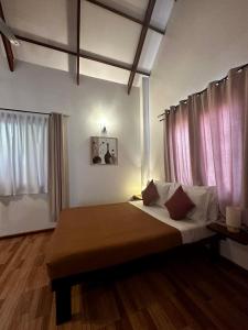 卢纳将军城Isola del Sole Villas and Resort的一间卧室配有一张带粉红色窗帘的大床