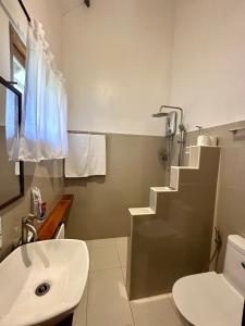 卢纳将军城Isola del Sole Villas and Resort的白色的浴室设有水槽和卫生间。