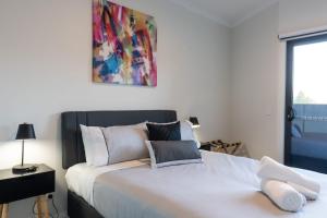 布赖特Mountain Mist Retreat - 6 Bedrooms的卧室配有一张床,墙上挂有绘画作品