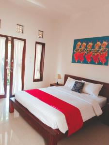 沙努尔Taman Bali Homestay的一间卧室配有一张带红色毯子的大床