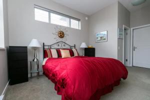 维多利亚Incredible Views Beautiful 2-Bedroom Suite的一间卧室配有一张带红色毯子的床