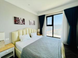 归仁ALTARA Quy Nhơn - RUBY Luxury Apartment的一间卧室设有一张大床和一个大窗户