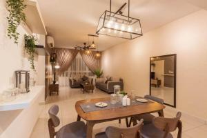 巴生Tastefully Designed 3BR at Impiria Residensi Klang的用餐室以及带桌椅的起居室。