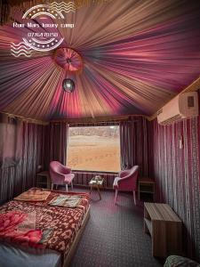 瓦迪拉姆Rum Mars luxury camp的一间火车车厢里的卧室,配有床和椅子