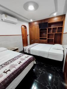 佩雷拉Hotel Miluansa的一间酒店客房,设有两张床和电视