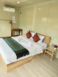 瓜隆岛Naroth Beach Bungalow的卧室配有一张带白色床单和枕头的大床。