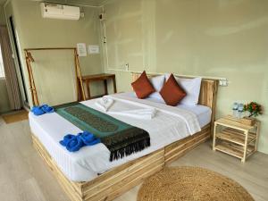 瓜隆岛Naroth Beach Bungalow的一间卧室配有一张带蓝色枕头的大床