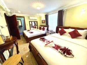 贡布AHHA Boutique Kampot的酒店客房配有两张床和一张书桌