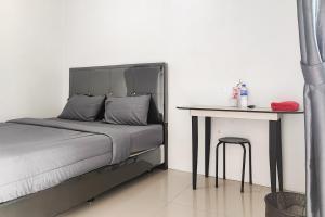 PaalmerahRedDoorz Syariah near Lapangan Persijam Jambi的一间卧室配有一张床和一张桌子及凳子