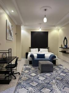 乌姆莱季فيلا الوريك Villa Al Warik的一间卧室配有一张床、一张桌子和一张地毯。