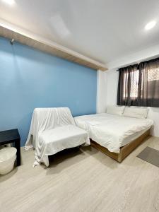 台中市FunSong逢甲的一间卧室设有两张床和蓝色的墙壁