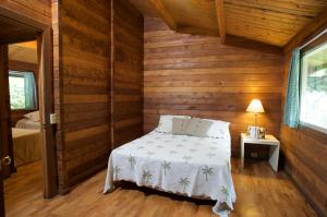 Waimea寇基山林小屋的木制客房内的一间卧室,配有一张床