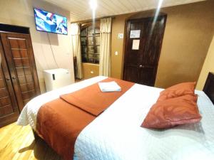 昆卡Hotel Calle Angosta的一间卧室配有一张带橙色毯子的床