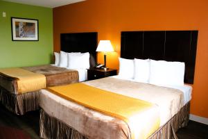 基林Scottish Inns Killeen near Fort Cavazos的绿墙旅馆客房的两张床