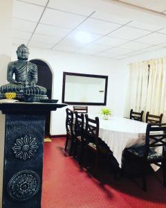 阿努拉德普勒Thissawewa guest的一间用餐室,内设一张桌子和一张雕像