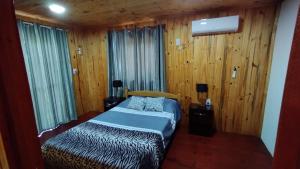 埃尔索韦维奥Alojamiento Matheo的一间卧室设有一张床和木镶板墙