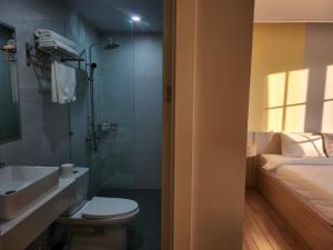 富国Hi Beach House Phu Quoc - Sunset Town的一间带卫生间、水槽和床的浴室