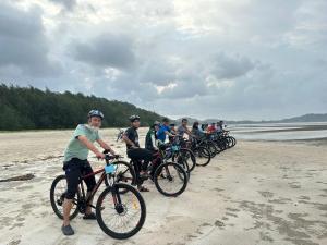Kampung MawarOcean Cottage 1, Radiant Teluk Sari的一群人在海滩上骑车