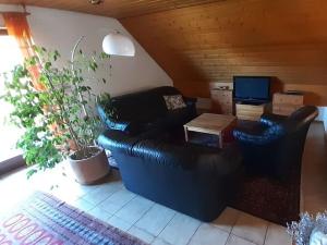 罗滕堡Holiday apartment Renate的客厅配有黑色真皮沙发和桌子