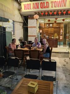 会安Hoian Old Town Hostel的一群坐在餐厅桌子上的人