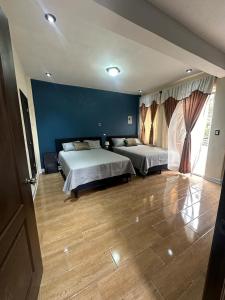 圣胡安拉拉古纳CASA DE DESCANSO TZANJAAY的一间卧室设有两张床和蓝色的墙壁