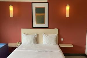 雅加达Hotel Glodok Plaza的一间卧室配有一张带两个白色枕头的床
