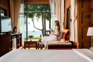 象岛象岛天堂度假村 的女士在窗户房间里读书