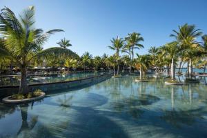 特鲁欧克比赫斯Trou aux Biches Beachcomber Golf Resort & Spa的度假村内棕榈树游泳池