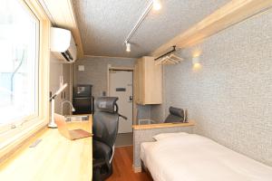 千岁JR Mobile Inn Chitose的一间卧室配有一张床、一张书桌和一个窗户。