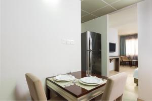 马斯喀特Centara Life Muscat Dunes Hotel的用餐室配有桌椅和冰箱