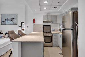 迪拜Sleek Studio - Red Residence-L8 - Near ISD Stadium的厨房配有不锈钢冰箱和台面