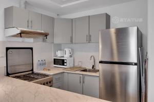 迪拜Sleek Studio - Red Residence-L8 - Near ISD Stadium的厨房配有白色橱柜和不锈钢冰箱