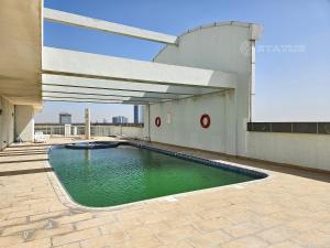 迪拜Sleek Studio - Red Residence-L8 - Near ISD Stadium的一座大楼顶部的游泳池