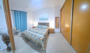卡耐特蒂贝兰格Apartamento con piscina y cerca de la playa的一间卧室配有床和蓝色窗帘