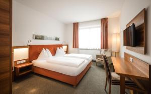 布列瑟农克拉拉酒店的配有一张床和一张书桌的酒店客房