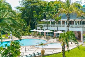 吉塞尼Lake Kivu Serena Hotel的享有酒店空中景色,设有游泳池和棕榈树
