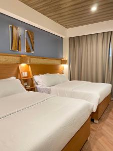 科隆阿卡西亚花园宾馆的配有白色床单的酒店客房内的两张床