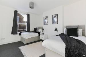 诺丁汉Perfect Retreat 4bed House Trent Bridge & Forest的一间白色卧室,配有两张床和窗户