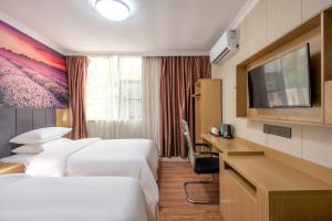 广州华旅酒店(广州北京路步行街省人民医院店)的酒店客房设有两张床和一台平面电视。