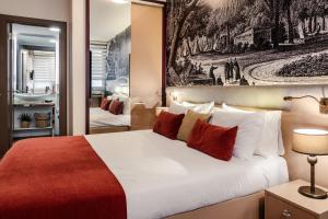 伊斯坦布尔Cheya Besiktas Istanbul Bosphorus City Center Hotel & Suites的一间卧室配有一张带红色和白色枕头的大床