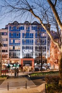 伊斯坦布尔Cheya Besiktas Istanbul Bosphorus City Center Hotel & Suites的一座大型建筑,前面的人在步行