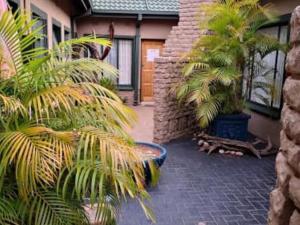 贝拉贝拉Dula Monate Holiday Flats的一座房子前面种有棕榈树的庭院