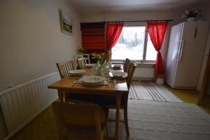 罗瓦涅米Traditional House Rovaniemi的厨房配有木桌、椅子和冰箱